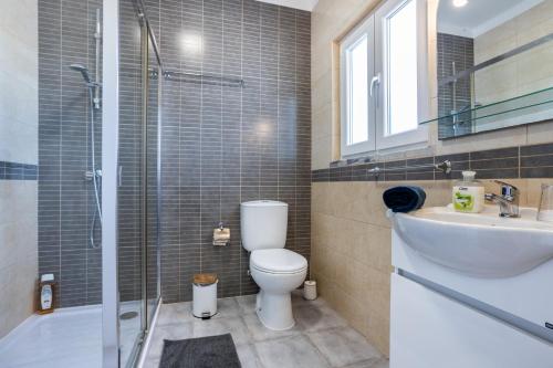 La salle de bains est pourvue de toilettes, d'un lavabo et d'une douche. dans l'établissement Villa Arrifana (Vale de Telha), à Aljezur