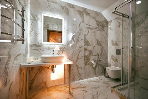 a marble bathroom with a sink and a shower at Гостиница Каретный дворик in Gelendzhik