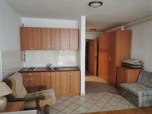 a kitchen with wooden cabinets and a living room at Kavana Stari krov in Donji Kraljevec