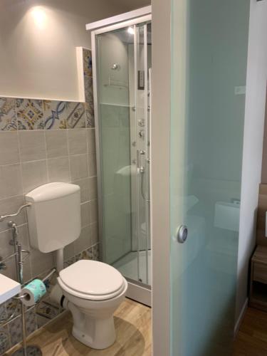 a bathroom with a toilet and a glass shower at DOMUS FIESCHI Rooms self check in in Genova