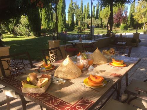 una mesa de picnic con comida encima en Fontaine des Magnarelles, en Althen-des-Paluds
