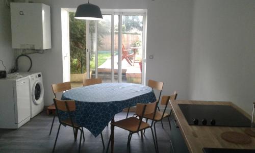 une cuisine avec une table, des chaises, une table et une table. dans l'établissement Gîte à 50m de la mer par chemin piétonnier !, à Réville