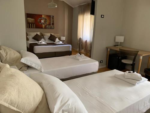 a hotel room with two beds and a couch at DOMUS FIESCHI Rooms self check in in Genova