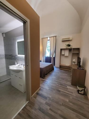a bedroom with a bed and a sink and a bathroom at Casa tua suites in Catania