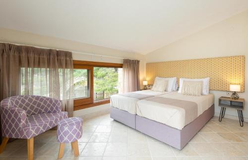 オルモス・パナギアスにある#FLH - Villa Louiseのベッドルーム(大型ベッド1台、椅子付)