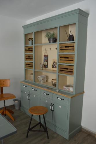 a large blue hutch with shelves and a stool at Zum Scheunenhof - Scheune in Ichenhausen
