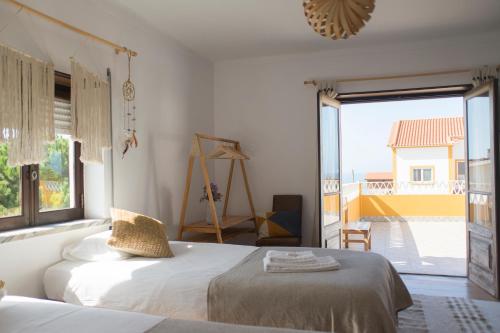 a bedroom with two beds and a large window at Ondina Guesthouse in Casais de São Lourenço