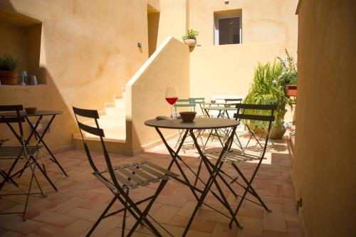 een patio met een tafel en een glas wijn bij Locanda Carra Manna in Sassari