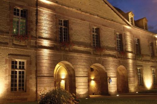 an old building with lights on the side of it at Hôtel Restaurant Aux Deux Roses in Neuf-Brisach