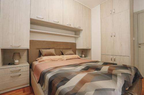 a bedroom with a bed and white cabinets at Apartments Viva Oliva in Budva