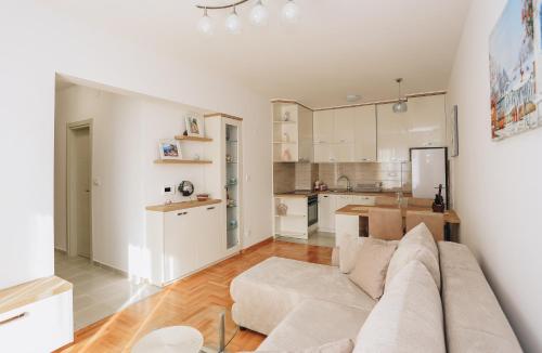 een woonkamer met een bank en een keuken bij Apartments Viva Oliva in Budva