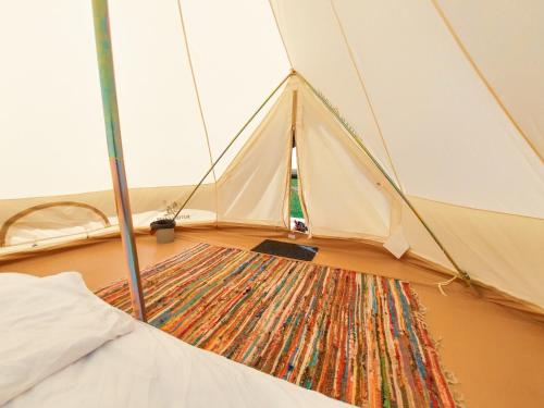 a tent with a rug in the middle of a room at Fain in Lunca Bradului