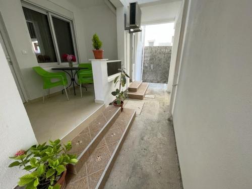 a hallway of a house with a table and green chairs at Apartments Pericic in Sutomore