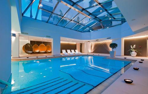 a large swimming pool with a blue ceiling at Porto Platanias Beach Resort & Spa in Plataniás