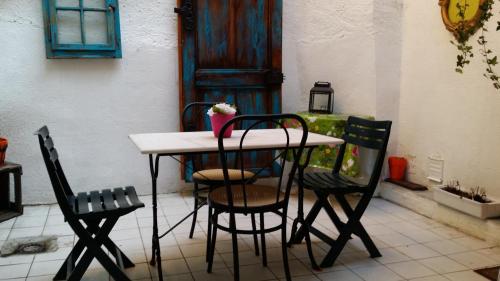 - une table et des chaises dans une pièce avec porte dans l'établissement Appartement Le Chez Soi Riquewihr, à Riquewihr