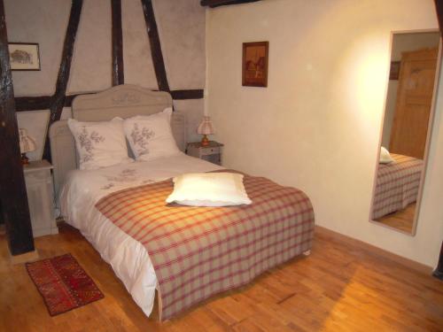 a bedroom with a bed with a striped blanket at Appartement Le Chez Soi Riquewihr in Riquewihr