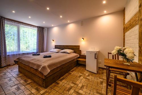 a bedroom with a large bed and a table at Place near beach in Pērkone