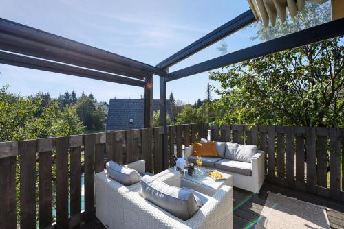 a patio with two couches on a wooden deck at Lakeside Hotel Plitvice in Plitvička Jezera
