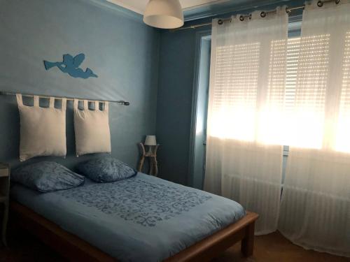 une chambre bleue avec un lit et une fenêtre dans l'établissement Lyon 3 Triangle d'Or, à Lyon