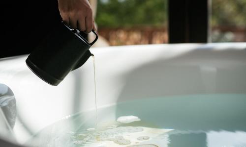 a person is pouring water into a table at The One Nanyuan in Xinpu