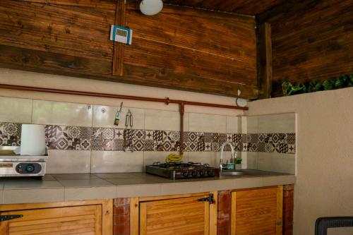 uma cozinha com armários de madeira e uma bancada em Let's do! Sunshine em Năvodari