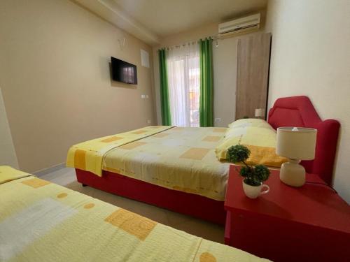 a bedroom with two beds and a red chair at Apartments Pericic in Sutomore