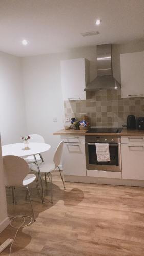 eine Küche mit einem Tisch und einem Herd Top-Backofen in der Unterkunft Heart Of Aberdeen City Centre 3 Bedrooms Apartment in Aberdeen