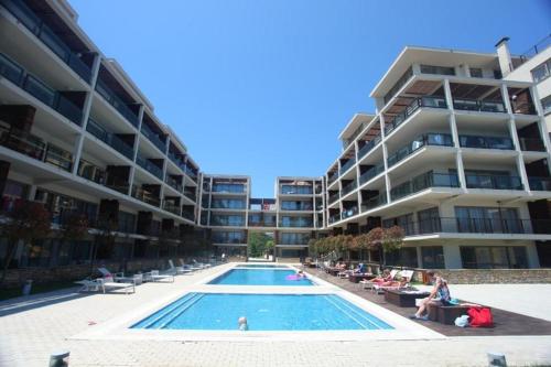 una piscina frente a un gran edificio de apartamentos en Yoo Bulgaria Apartments -c306 en Obzor