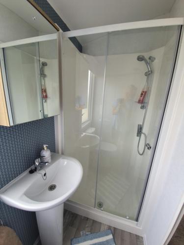 baño blanco con ducha y lavamanos en Devon holiday en Goodrington
