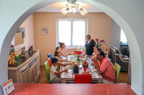 un groupe de personnes assises autour d'une table à manger dans l'établissement Le Nid de l'Ecureuil, à Brens