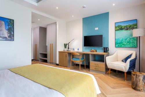 a bedroom with a bed and a desk with a television at Ulwazi Place Hotel by Trianum in Nairobi