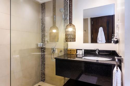 a bathroom with a sink and a shower at Ulwazi Place Hotel by Trianum in Nairobi