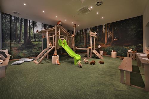 a room with a playground with a slide at Hotel Element in Lipno nad Vltavou