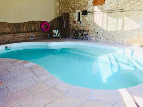 uma grande piscina azul num edifício de pedra em Maison Aubergerac em Bergerac