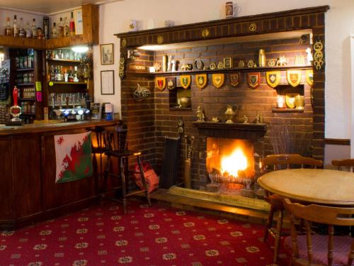 a fireplace in a pub with a table and a fire place at The George Borrow Hotel in Ponterwyd