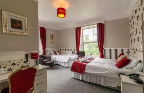 a hotel room with two beds and a couch at The George Borrow Hotel in Ponterwyd