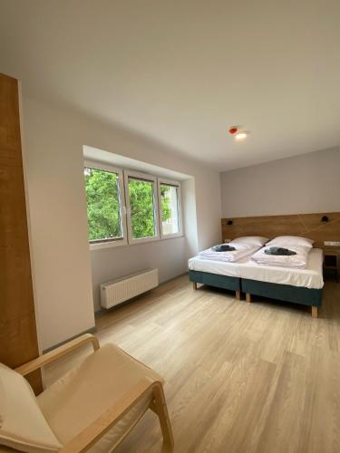 a room with two beds and a chair in it at APARTAMENTY ZDROJOWA 9 in Duszniki Zdrój