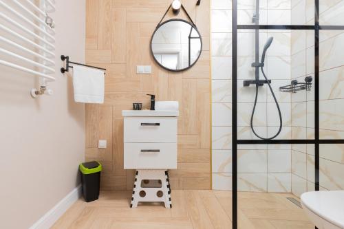 W łazience znajduje się umywalka i lustro. w obiekcie Jastrzebia Gora - Wiatrakowa Apartments by Renters w Jastrzębiej Górze