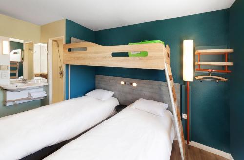 two bunk beds in a room with blue walls at ibis budget Porte D'Orleans in Paris