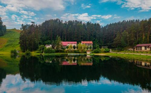 un reflejo de una casa en un lago en Svečių namai ALDAIVITA en Ignalina