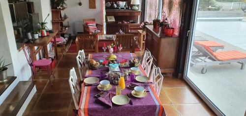 Domaine de Millox في Saint-André-de-Seignanx: طاولة طعام مع قطعة قماش أرجوانية