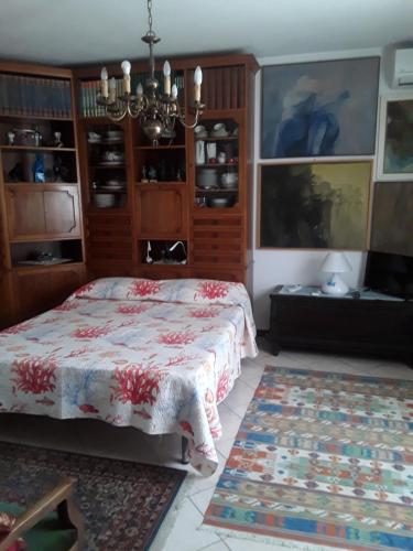 a bedroom with a bed and a chandelier at L'Onda in Oristano