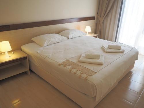 duże białe łóżko z dwoma ręcznikami w obiekcie Atlas Cesme Apartments w mieście Çeşme