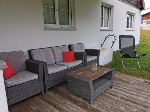 a patio with two couches and a table and a chair at Tgèsa Dutg Grond in Sedrun