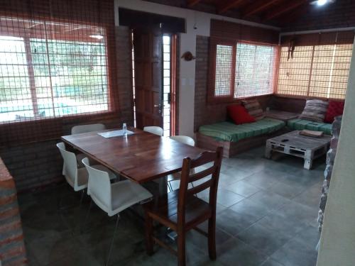 a dining room with a table and chairs and a couch at Cabaña El Mirador de Bialet Masse in Villa Parque Siquiman