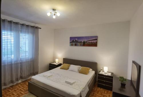 a bedroom with a bed and a window at Apartman Sara in Preko