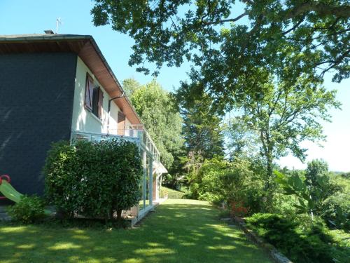 a house with a green yard next to a building at Résidence Bellevue in Pontacq