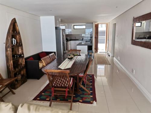 a kitchen and living room with a wooden table and chairs at Apartment 13 Santana Pebbles, 164 South Beach Road, La Mercy in La Mercy