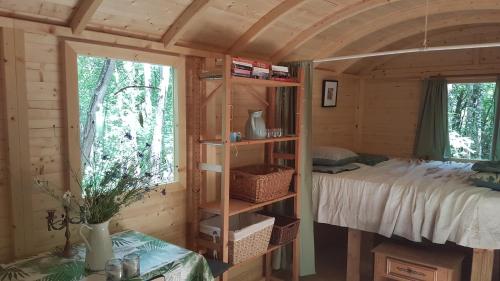 een slaapkamer met een bed in een houten hut bij Charming Cottage in Chauminet in Sougères-en-Puisaye