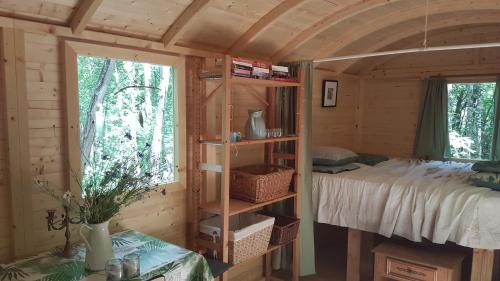a bedroom with a bed in a wooden cabin at Charming Cottage in Chauminet in Sougères-en-Puisaye
